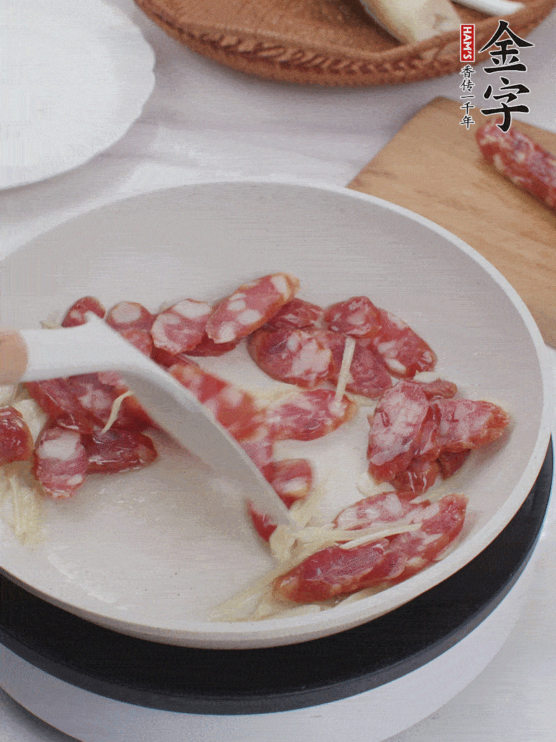 油溫3成熱時，下姜絲、蒜片、香腸炒出油脂。