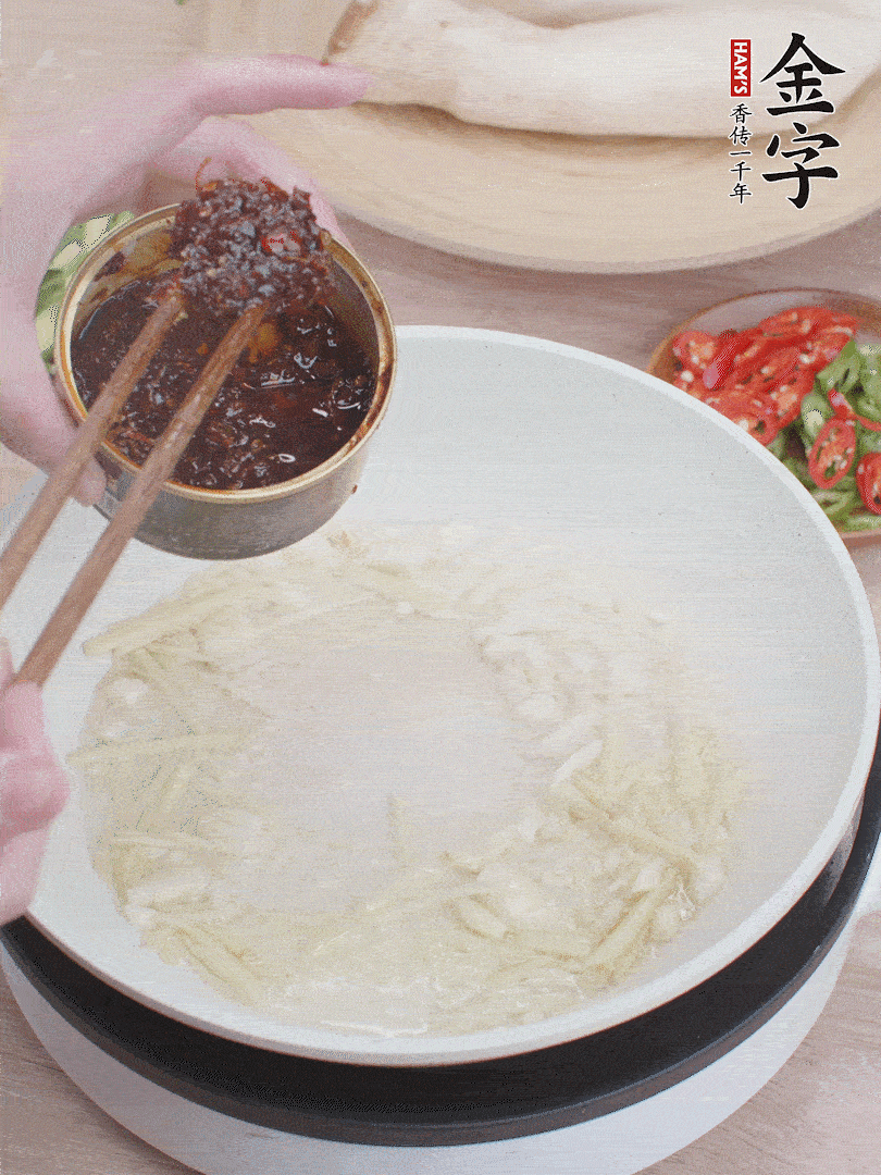 起鍋熱油，姜蒜、金字火腿干貝醬煸香。