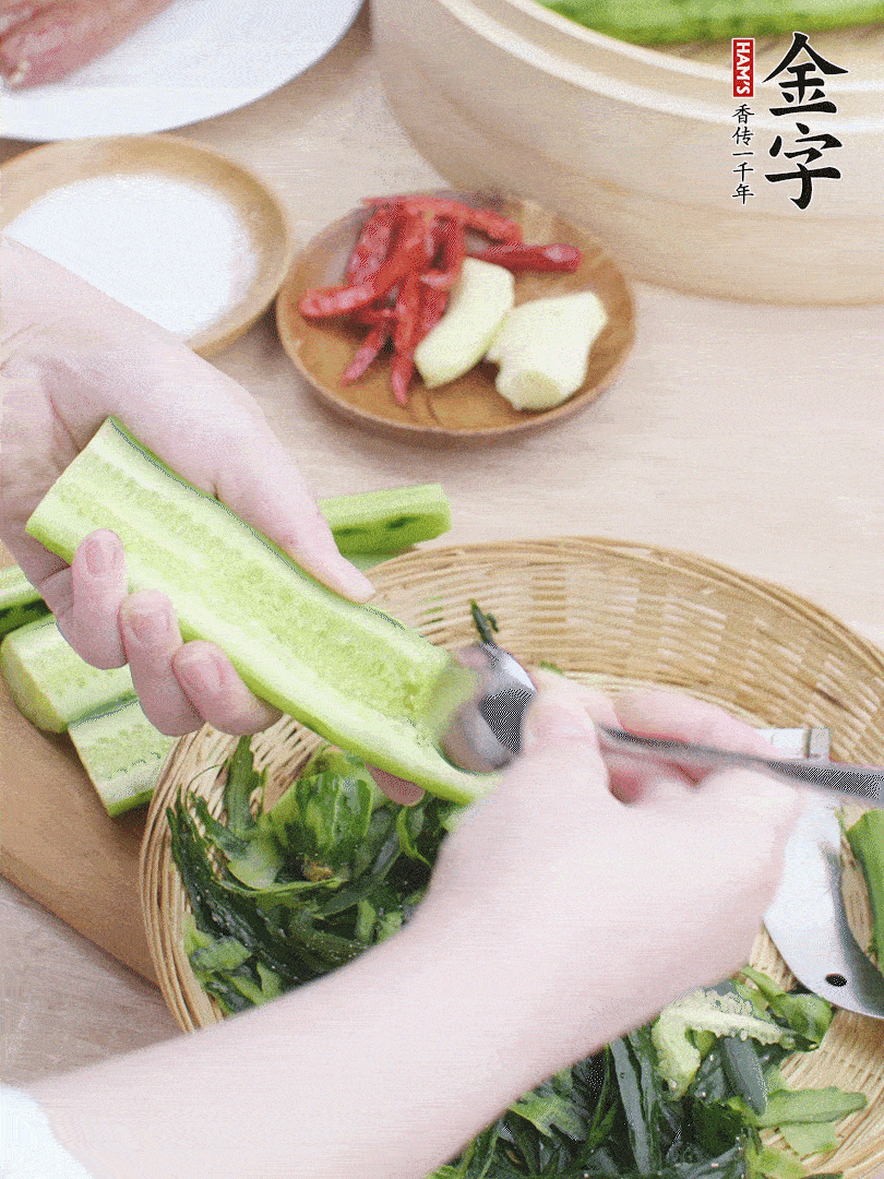 黃瓜削皮，對半切開，勺子挖去內瓤，斜刀切片。青蒜斜刀切段。