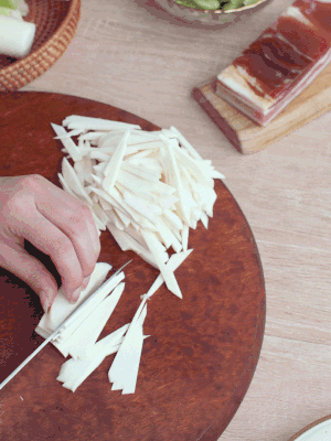 茭白切細(xì)絲，鹽水中浸泡防止氧化。