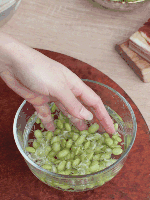 青豆剝殼，搓去外衣。