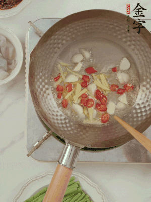 油7成熱時(shí)，下大蒜粒、姜絲、小米辣煸香。