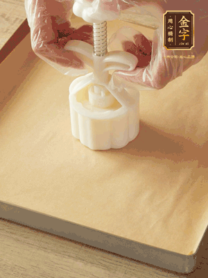 取一個(gè)面團(tuán)，捏扁，中間厚，四周薄?；⒖谕贤?，直到收口，把餅胚放入模具里，壓2-3下